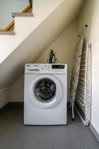 a washing machine in a room with a staircase at De Rieke in Ronse
