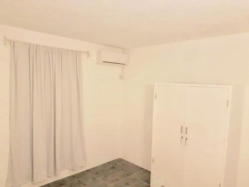 a room with a white cabinet and a window at BREEZE DU NORD in Grand Baie