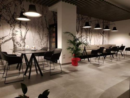 a dining room with black chairs and tables and plants at AREA 19 in Catanzaro