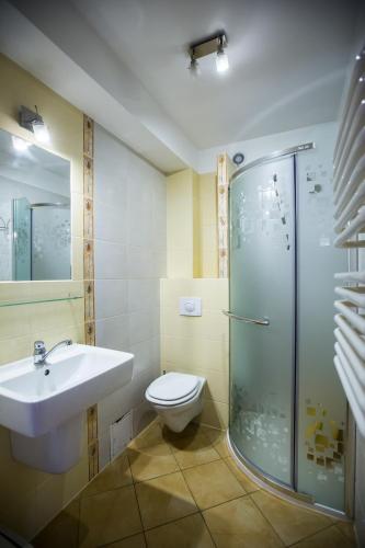 a bathroom with a toilet and a sink and a shower at Pokoje gościnne Jolka in Łeba