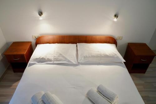 a bedroom with a white bed with two night stands at Sesar Apartments Krk - No. 1 Iva in Krk