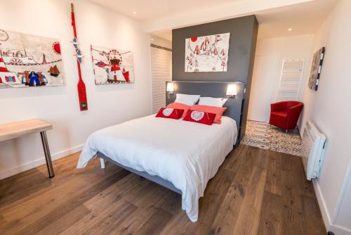 a bedroom with a large white bed with red pillows at Le Clos de la Pointe Saint-Mathieu in Plougonvelin