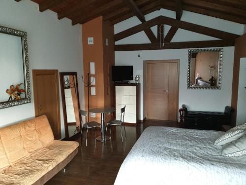 a bedroom with a bed and a table and a couch at casa cristimil -san amaro in Salamonde
