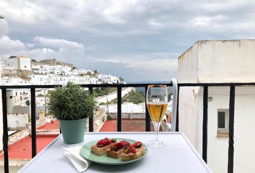 una mesa con un plato de comida y una copa de vino en Casa El Patio, en Vejer de la Frontera