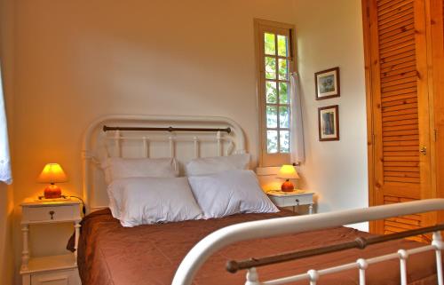 a bedroom with a bed with two lamps on tables at Casa da Canada in Ribeira Grande