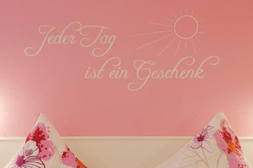 a pink wall with a sign that reads faster tap its an essential at Winneburger Hof in Ernst