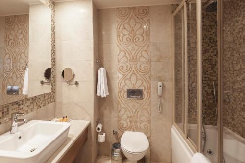a bathroom with a toilet and a sink and a shower at Melas Lara Hotel in Lara