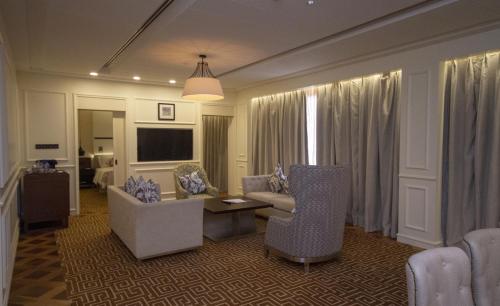 a living room with chairs and a couch and a tv at Movenpick Hotel & Convention Centre KLIA in Sepang