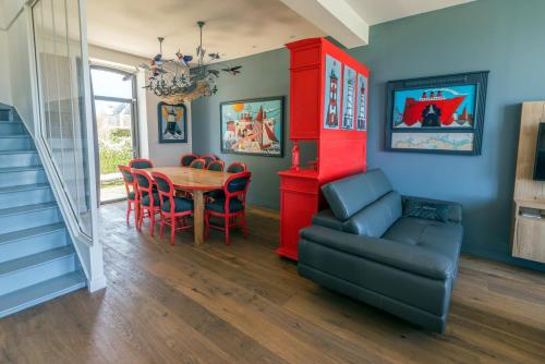 a dining room with a table and a red cabinet at Le Clos de la Pointe Saint-Mathieu in Plougonvelin
