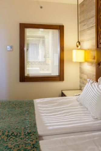 a bedroom with a white bed and a window at Melas Lara Hotel in Lara