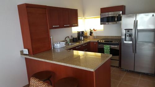a kitchen with wooden cabinets and a stainless steel refrigerator at Casa Tu Paz in La Paz