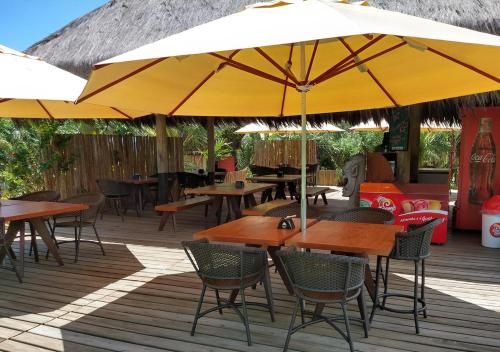 an outdoor patio with tables and chairs and umbrellas at Pousada Vila Araticum in Santo André