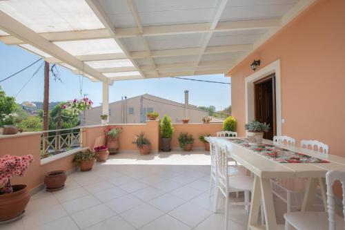 a patio with a table and chairs on a balcony at Corfu Villa Potamaki in Corfu