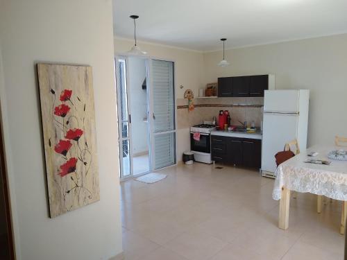 a kitchen with a refrigerator and a table in it at JUANA II in Villa Elisa