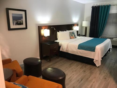 a hotel room with a large bed and chairs at Hotel Pensacola in Pensacola