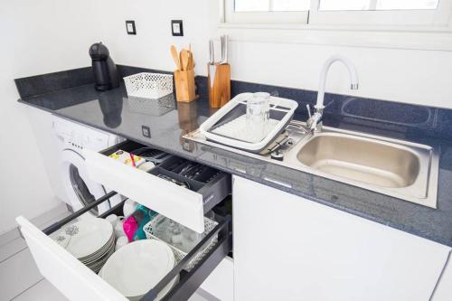 a kitchen counter with a sink and a dishwasher at Gîte spacieux avec Jacuzzi - ****5 étoiles**** in Baie-Mahault