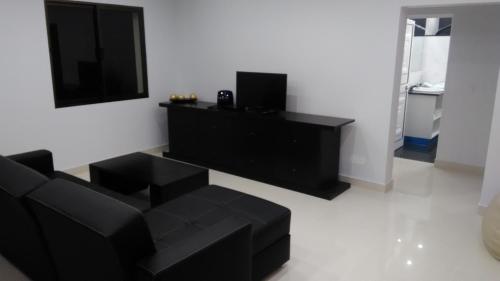 a living room with a black couch and a flat screen tv at Vista Atlântico in Gaula