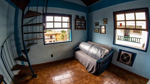 sala de estar con sofá y escalera de caracol en Flat Âncora, en Cabo Frío