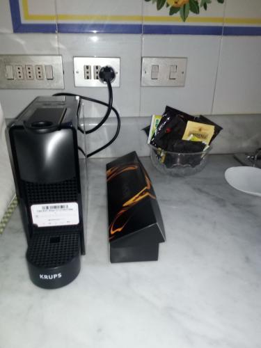 a computer on a counter with a charger and a box at B&B Palazzo Bianchi in Parma