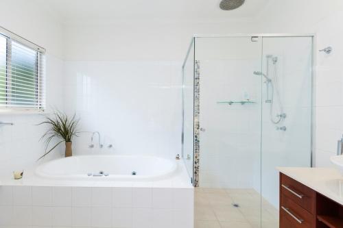 a white bathroom with a tub and a shower at Bella vista in Maslin Beach