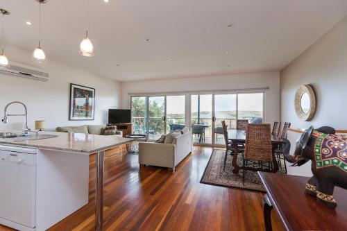an open living room with a kitchen and a living room at Bella vista in Maslin Beach