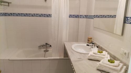 La salle de bains blanche est pourvue d'un lavabo et d'une baignoire. dans l'établissement Azul Rentals Albir flat, à Albir