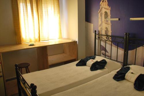 a bedroom with two beds and a window at Oikeion in Ermoupoli
