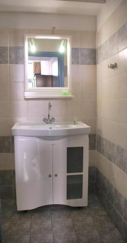 a bathroom with a sink and a mirror at Oikeion in Ermoupoli