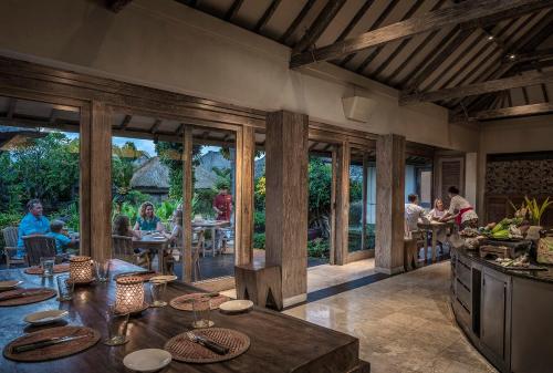 a kitchen with people sitting at tables in a restaurant at Four Seasons Resort Bali at Jimbaran Bay in Jimbaran