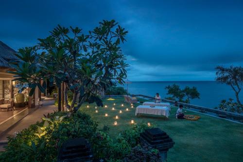 a backyard with a table and lights on the grass at Four Seasons Resort Bali at Jimbaran Bay in Jimbaran