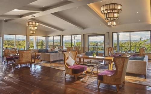 a restaurant with chairs and tables and windows at Quest Plus Conference Center, Clark in Clark