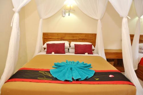 a bedroom with a bed with a flower on it at Nick's Homestay in Ubud