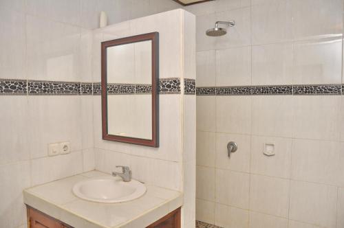a bathroom with a sink and a mirror at Nick's Homestay in Ubud