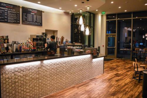 a man standing at a bar in a restaurant at Texas A&M Hotel and Conference Center in College Station