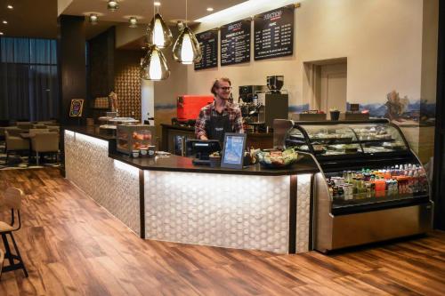 a woman standing behind a counter in a restaurant at Texas A&M Hotel and Conference Center in College Station