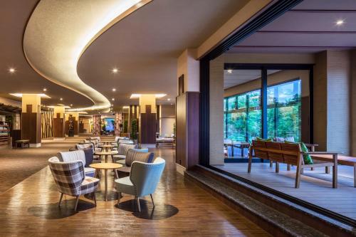 a hotel lobby with chairs and tables and windows at Kiki Shiretoko Natural Resort in Shari
