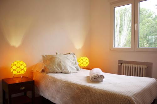 a bedroom with a bed with two lamps and a window at Casa Piedra Libre in Manzanares el Real