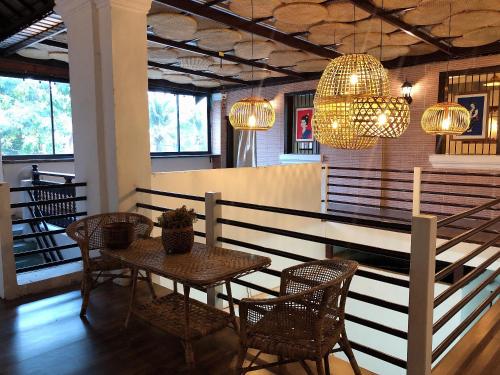 a dining room with a table and chairs and chandeliers at 1918’s HOSTEL in Pakse