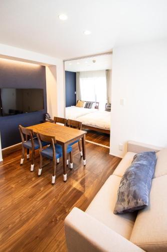 a living room with a table and a couch at Apartment Hotel Tenjin TUMUGU in Fukuoka
