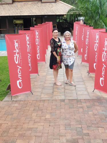 two women are standing in front of red signs at Nkomazi Kruger Lodge & Spa in Malelane