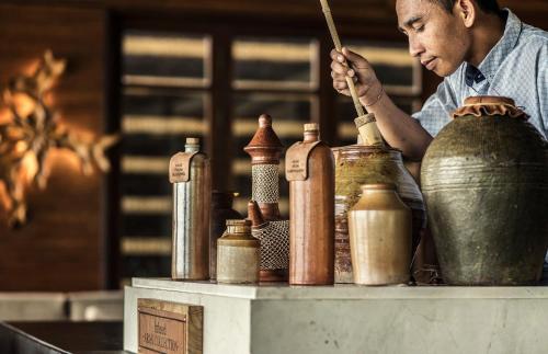 a man is making a pot on a table at Four Seasons Resort Bali at Jimbaran Bay in Jimbaran