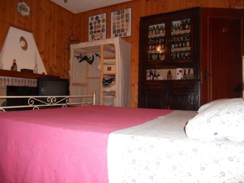 a bedroom with a bed with a pink blanket at B&B Pervinca in Rocca Grimalda