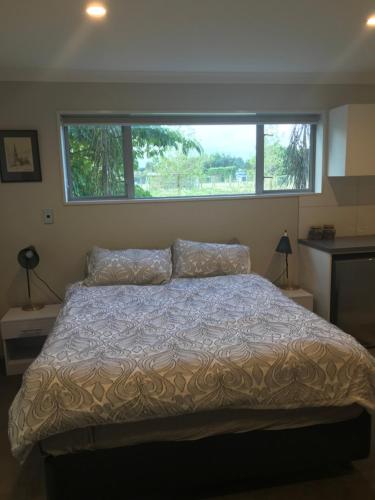 1 cama en un dormitorio con ventana grande en Broadfield, en Rolleston