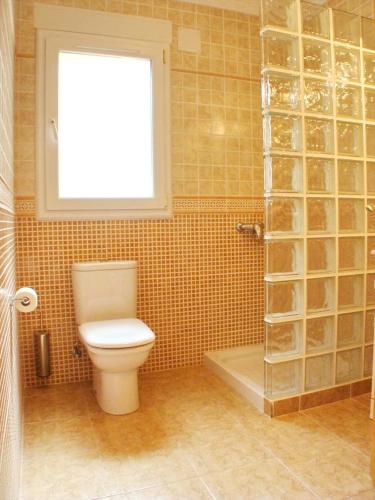 a bathroom with a toilet and a window and a shower at Villa Evora in Moraira
