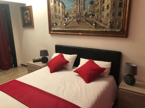 a bedroom with a bed with two red pillows at Roma Papalina in Rome