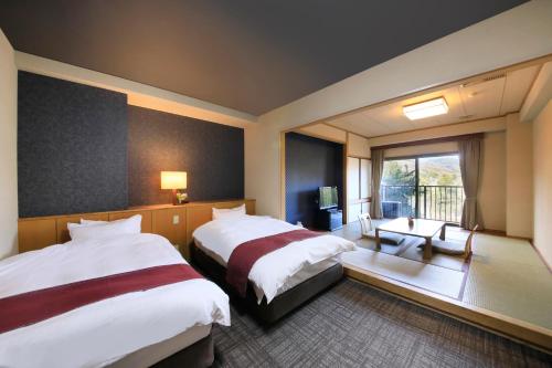 Postel nebo postele na pokoji v ubytování Hotel Kamogawaso
