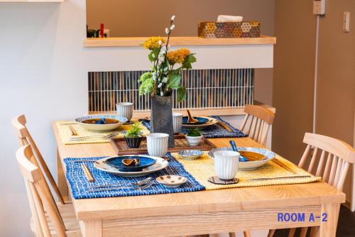 a dining room table with a blue and yellow table cloth at MEIBI Hakone Yumoto in Hakone