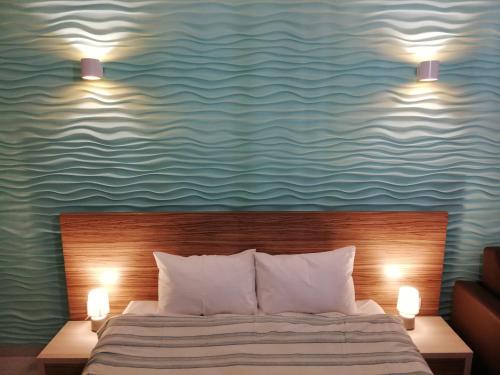 ママイアにあるDelos Studio With Sea Viewのベッドルーム1室(ベッド1台、上部に2つの照明付)