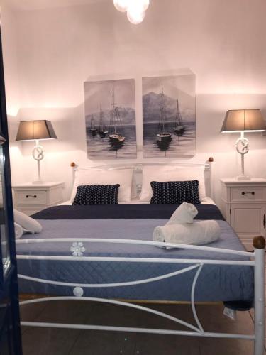 a bedroom with a bed with three pictures of boats at Estella’s House in Livadia