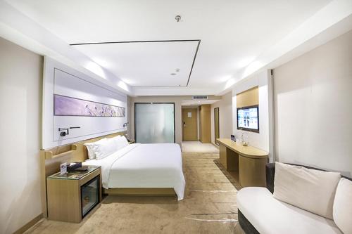 um quarto de hotel com uma cama e um sofá em Lavande Hotel Beijing Asian Games Village em Pequim